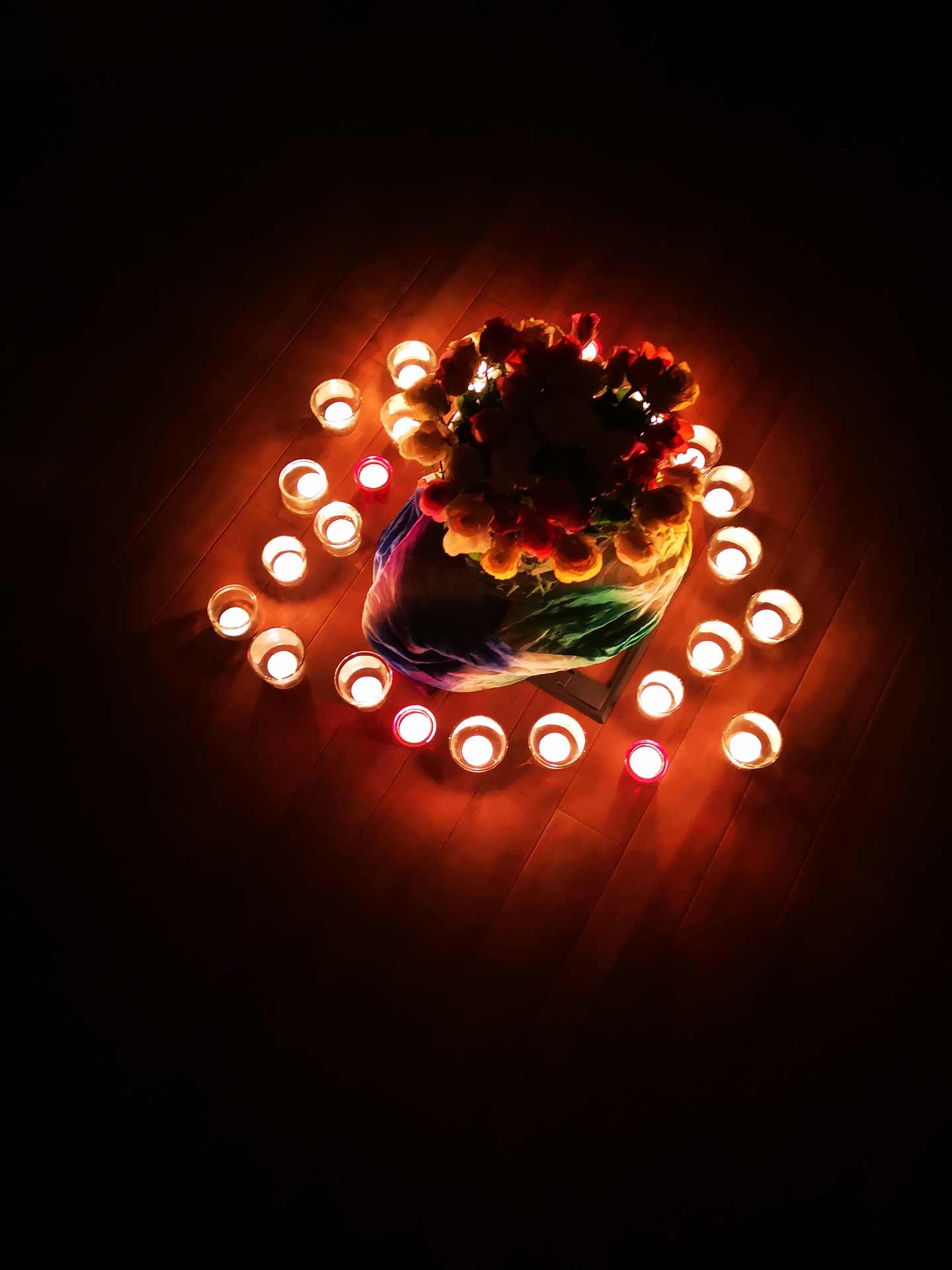 Bunter Blumenstrauß, umgeben von einem Kreis aus kleinen, brennenden Teelichtern beim der Trauergruppe Waldram